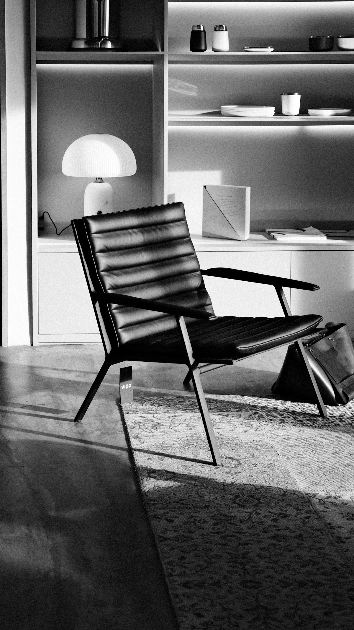 A modern black leather chair in a sunlit room