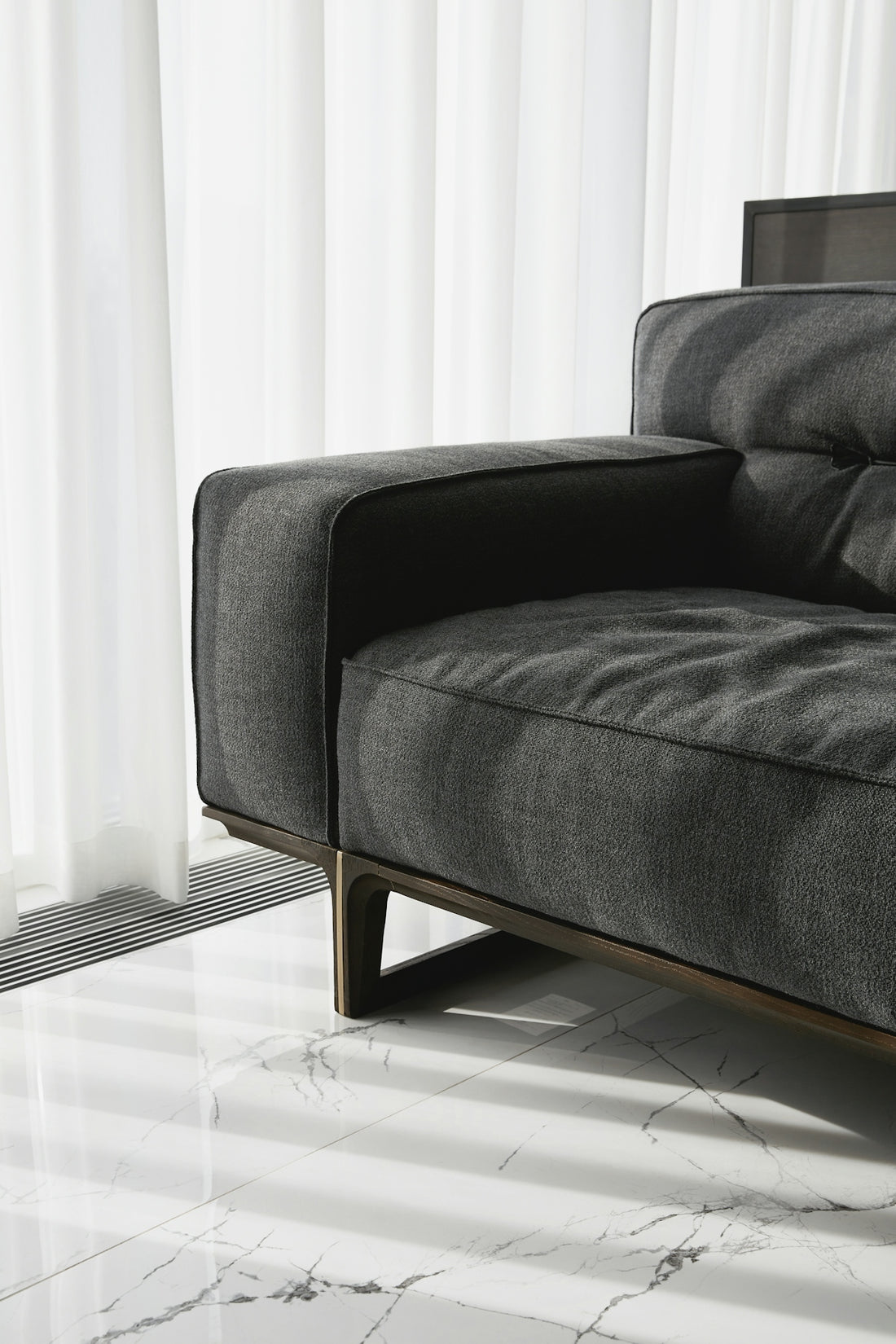 A modern grey sofa with wooden legs.