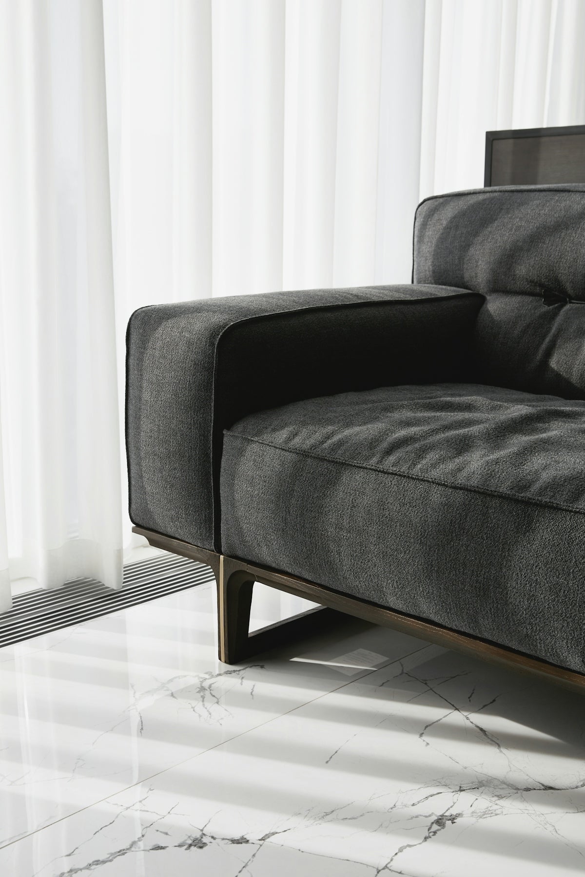 A modern grey sofa with wooden legs.