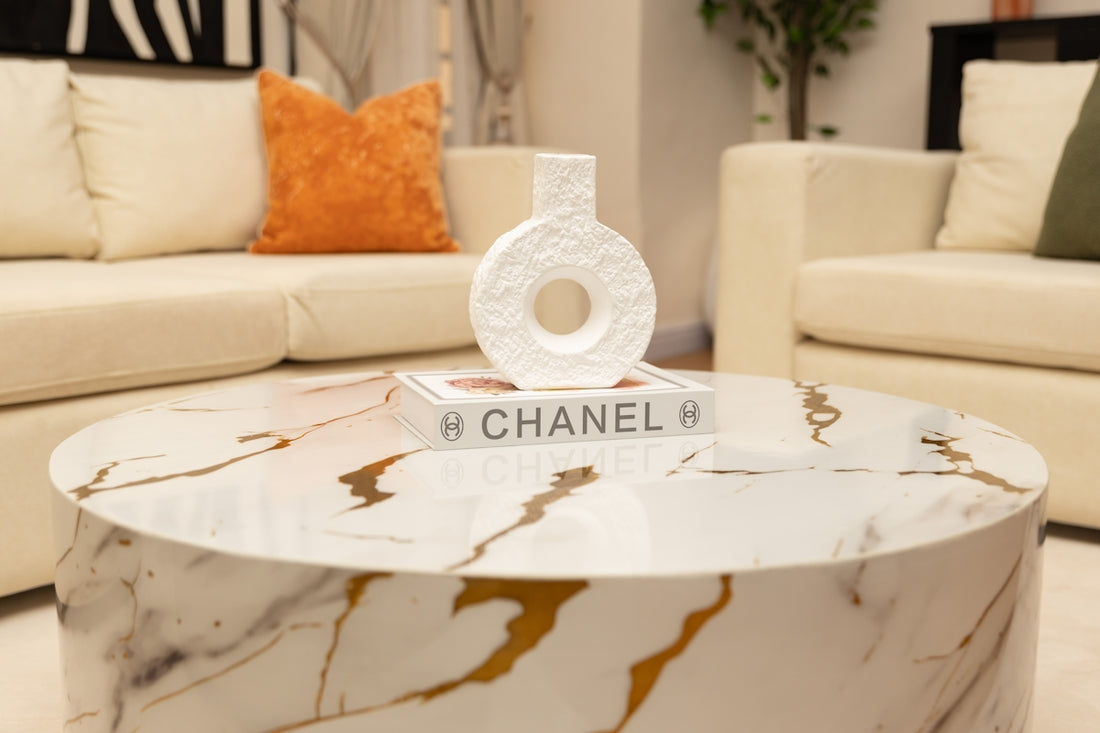 White marble coffee table with a decorative vase and book.